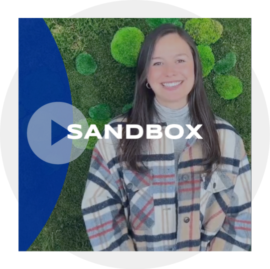Project Sandbox - a female on a green surface and the word "sandbox" in front